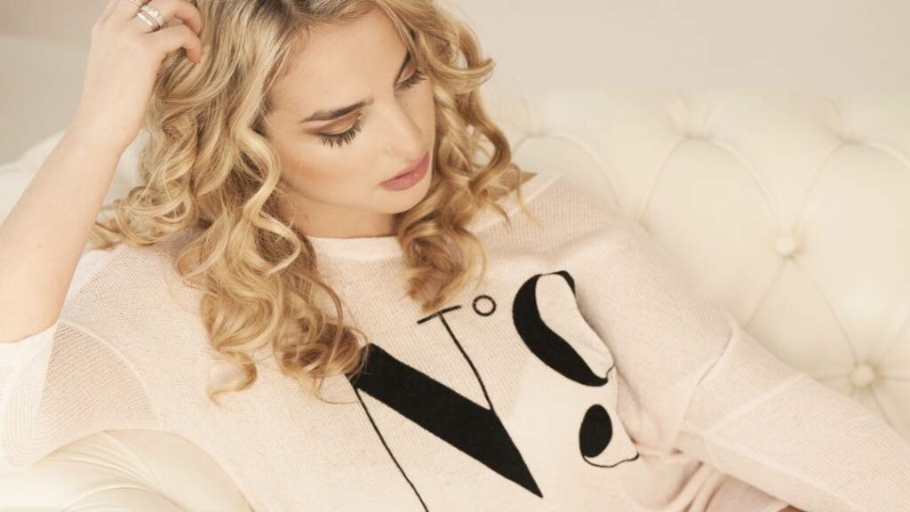 Woman in white with Curly blonde Hair