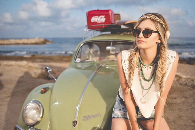 Woman from festival sat on VW beetle with plait hair