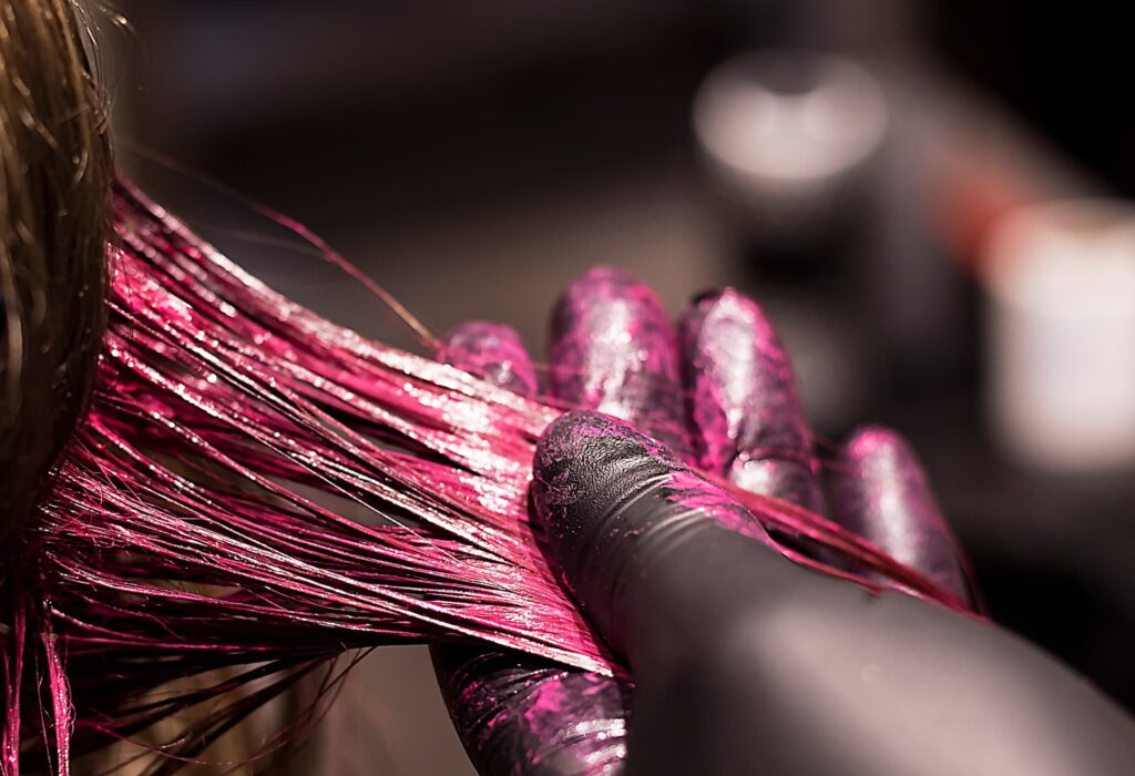 Closeup of woman in salon getting pink hair colouring