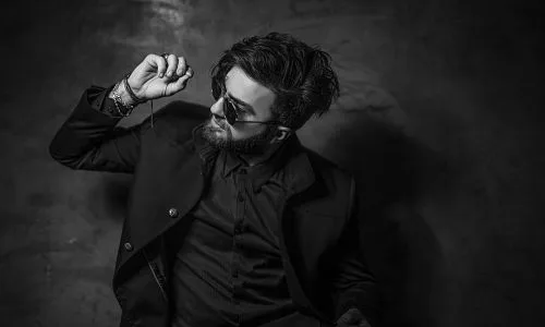 Men's Hairdressing shows a very cool model with fashionable hair in a dark setting.