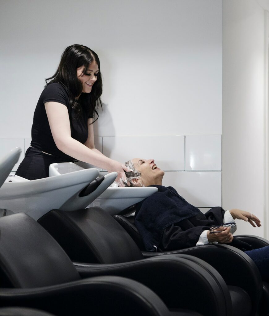 A picture of one of our happy clients being shampooed by an assistant technician